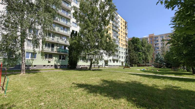 Sídlisko so zeleňou a budovami, vhodné na bývanie v 2-izbovom byte v Žiline.